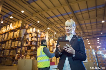 Female manger using digital tablet in distribution warehouse