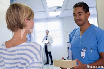 Female patient giving gift to doctor in hospital
