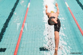 Female swimmer diving into swimming pool