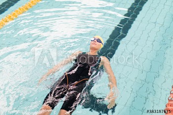 Female swimmer floating on back in swimming pool