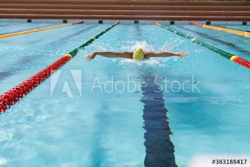 Female swimmer practicing butterfly stroke in swimming pool