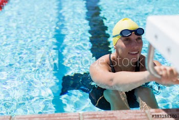 Female swimmer practicing in sunny swimming pool