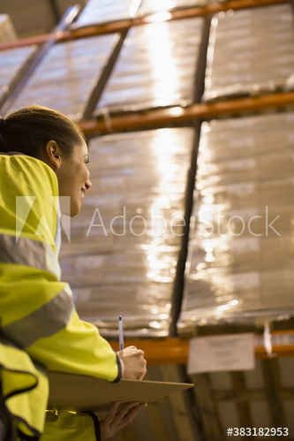 Female worker checking inventory in distribution warehouse
