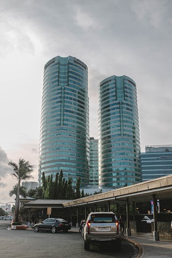 Few Vehicles Parking Near Road Viewing High-rise Buildings Under Gray Sky