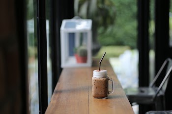 Filled Clear Glass Cup on Brown Wooden Table