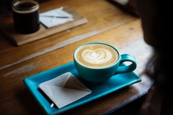 filled teal coffee cup and liner