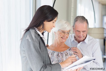 Financial advisor discussing paperwork with senior couple