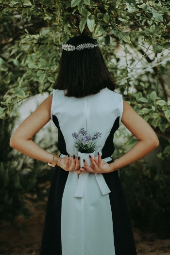 Fine art portrait of a model holding a plant and walking in a forest path