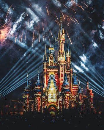 Fireworks Display Above Blue, Brown, and Red Castle