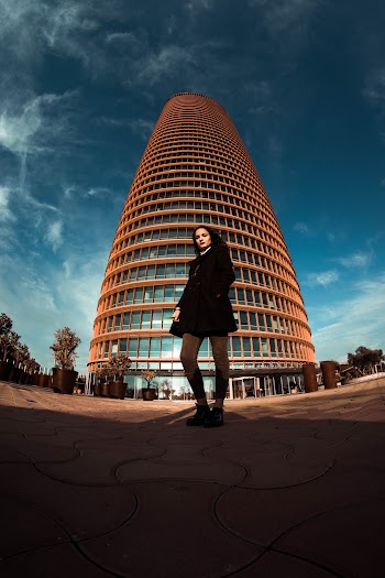 Fish-Eye Photography of Woman Standing in Front of Tall Building