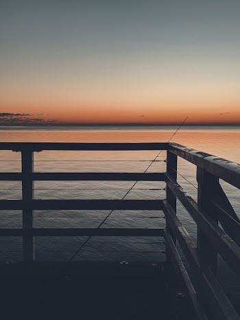 Fishing Rod Leaning on Wooden Rail