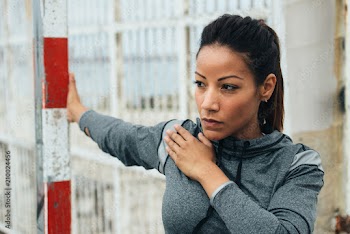 Fitness woman doing chest stretching exercise. Female motivated athlete working out and warming up outdoor. Healthy and sport lifestyle concept.