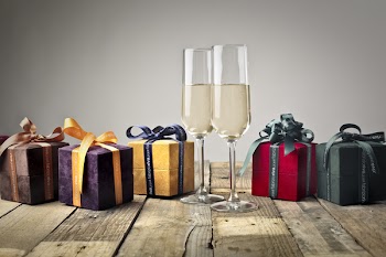 Five Assorted-color Gift Boxes and Two Footed Glasses on Top of Table