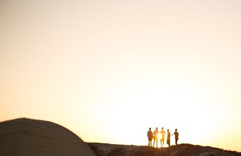 five men standing on a cliff