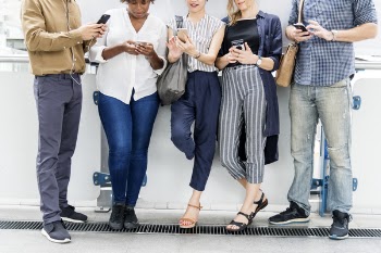 Five People Leaning On Wall While Using Smartphones