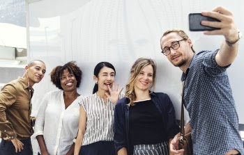 Five People Taking Groufie in Room