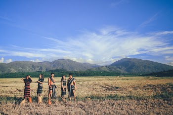 Five People Wearing Native Apparel Standing on Brown Grassfield Under Blue and White Cloudy Sky