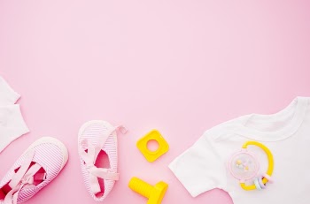 Flat lay baby clothes with pink background Free Photo