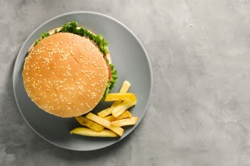 Flat-lay burger and fries on plate with copyspace Free Photo