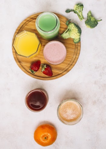 Flat lay colorful arrangement of smoothies and fruits Free Photo