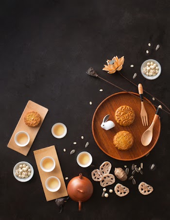 Flat lay mid autumn festival food and drink on rustic black background. Text space image.