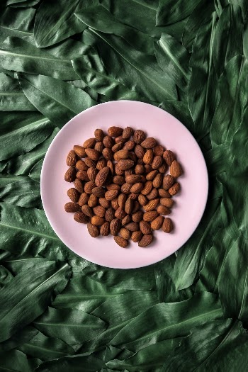 Flat lay photo of dark green wild onion leaves also known in Serbia as Sremus, with a pale pink plate of baked nuts in the center.
Food blogger and social media influencer graphic shop https://creativemarket.com/NordWood