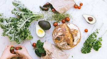Flat-lay Photograph of Bread, Tomatoes, and Avocados