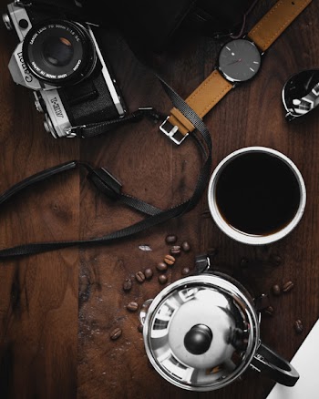 Flat Lay Photography of a Camera, Coffee Mug and Wristwatch