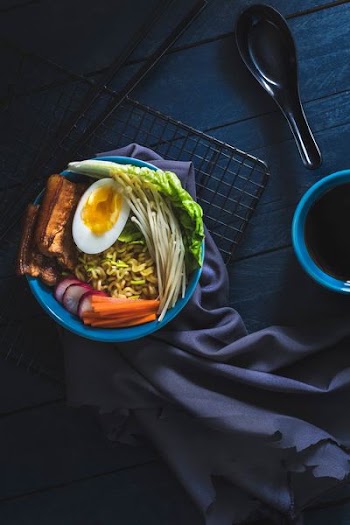 flat lay photography of ramen beside black spoon