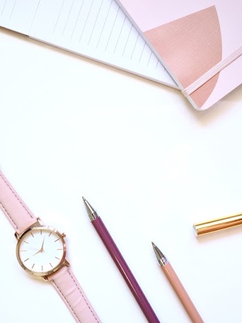Flat lay Photography of Watch Near Pens and Notebook