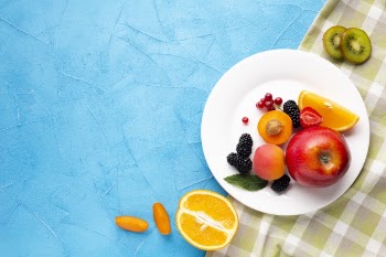 Flat-lay plate of fresh berries and fruits with copyspace Free Photo
