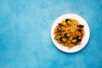 Flat-lay plate of mussel pasta with copyspace Free Photo