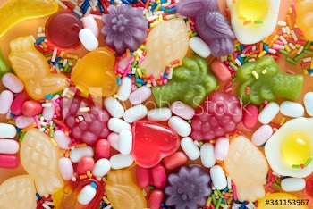 Flatlay of assorted jelly fruits and sprinkles textured background