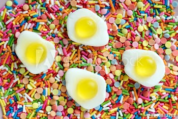 Flatlay of jelly fried eggs and sprinkles textured background