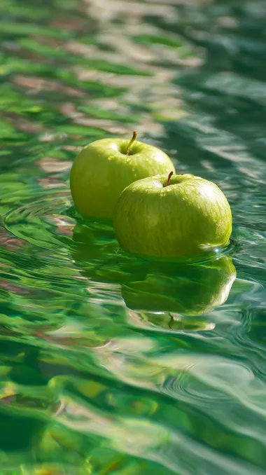 Floating Green Apples on Reflective Water Floating Green Apples on Reflective Water