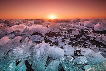 floating ice on ocean during sunset
