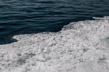 Foamy Water Crashing To Shore