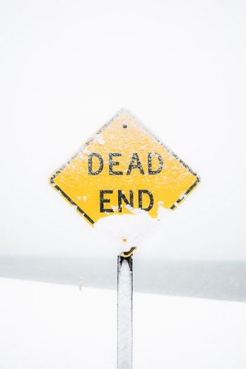 focus photography of dead end road sign covered with snow