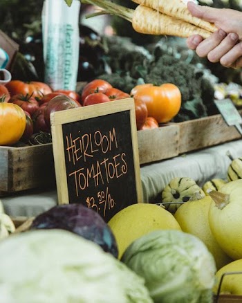 focus photography of heirloom tomatoes board signage