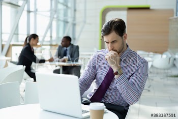 Focused businessman working at laptop in cafe