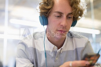 Focused creative businessman with headphones listening to music
