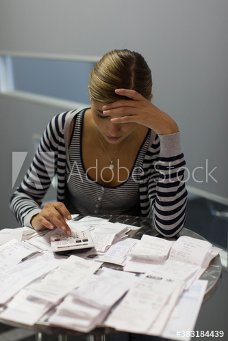 Focused female accountant calculating receipts in office
