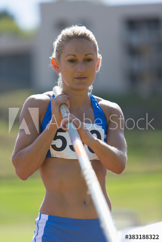Focused female athlete preparing to pole vault