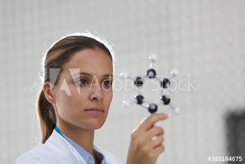 Focused female scientist examining molecule model