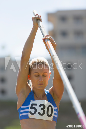 Focused female track and field athlete preparing for pole vault