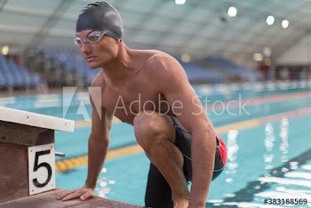 Focused male swimmer getting out of swimming pool