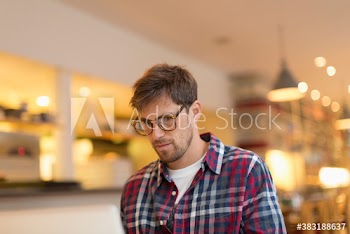 Focused man working at laptop in cafe