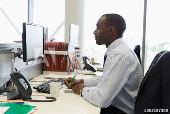 Focused young businessman working at computer in office