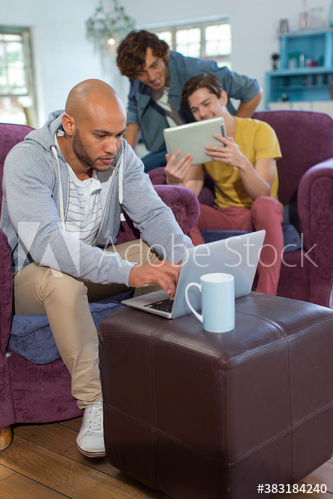 Focused young man using laptop in living room