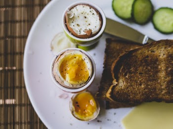 Foods on Plate Topped With egg cups with boiled eggs